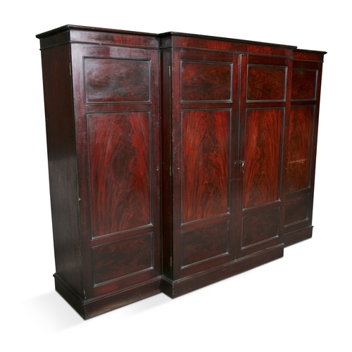 133 - A GEORGE IV MAHOGANY FOUR-DOOR WARDROBE,  of breakfront design, with simple moulded cornice above fi... 