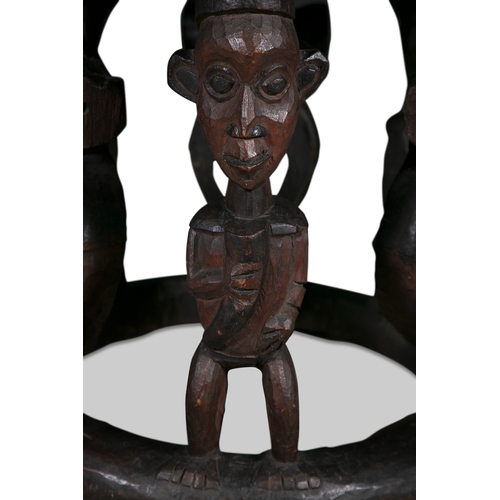 245 - A PAIR OF AFRICAN CARVED WOOD FIGURAL STOOLS,   probably Cameroon, each of circular shape with dishe... 