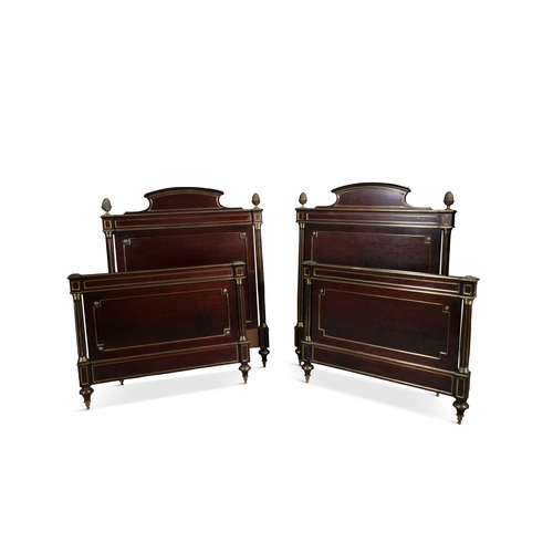 58 - A PAIR OF FRENCH MAHOGANY AND GILT BRASS MOUNTED EMPIRE SINGLE BEDS,   the head boards with raised a... 