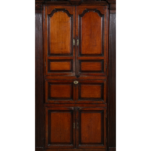 529 - A GEORGE III OAK CORNER CABINET,  the swan neck pediment with rosette terminals, twin fielded panel ... 