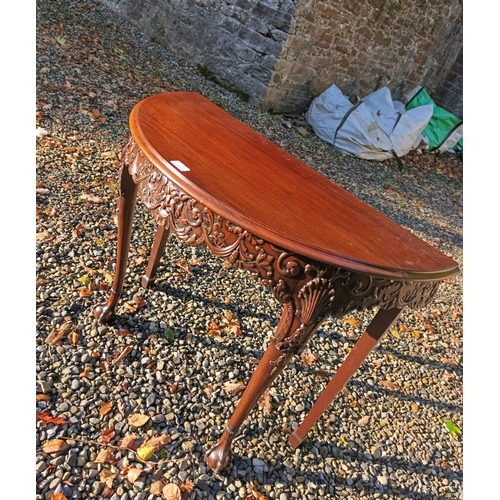 77 - A COMPOSED CARVED MAHOGANY D-SHAPED SIDE TABLE 18TH CENTURY,   with solid panel top above a masked f... 