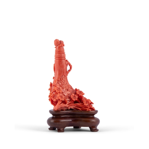 457 - *A CARVED RED CORAL VASE SHAPED SNUFF BOTTLE ON A WOODEN STAND  China, 20th century  H. 10cm  Weight... 