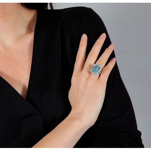 129 - AN AQUAMARINE AND DIAMOND DRESS RING  The rectangular-cut aquamarine weighing 10.56cts, within a bri... 