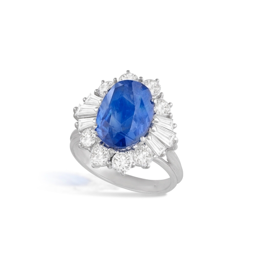 137 - A SAPPHIRE AND DIAMOND CLUSTER RING  The oval-shaped sapphire weighing approximately 5.14cts, within... 