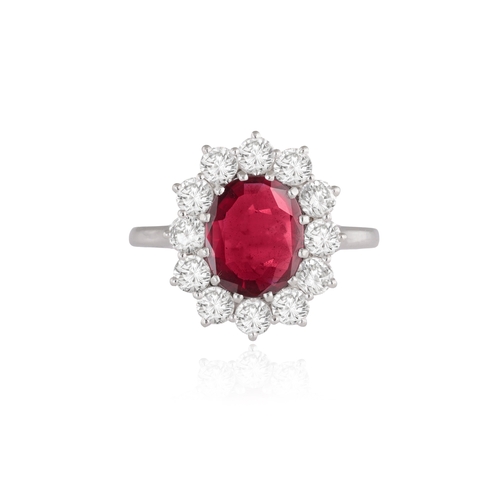 145 - A RUBY AND DIAMOND CLUSTER RING  The oval-shaped ruby weighing 1.90cts within a multiple-claw settin... 