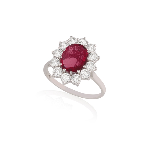 145 - A RUBY AND DIAMOND CLUSTER RING  The oval-shaped ruby weighing 1.90cts within a multiple-claw settin... 