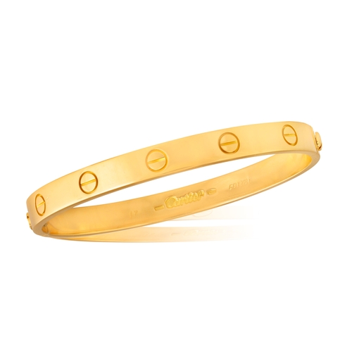 156 - CARTIER: AN 18K GOLD 'LOVE BRACELET', CIRCA 2000   The hinged bangle decorated with screw motifs, in... 