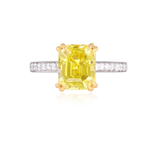 159 - A YELLOW SAPPHIRE AND DIAMOND DRESS RING  The cut-cornered rectangular yellow sapphire, weighing 4.0... 