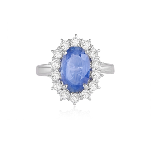 232 - A SAPPHIRE AND DIAMOND CLUSTER RING  The oval-shaped sapphire weighing approximately 3.10cts, within... 