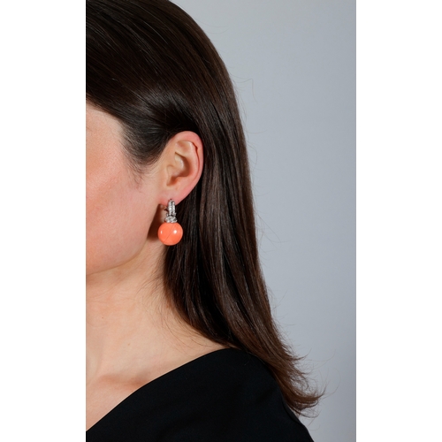 257 - A PAIR OF CORAL AND DIAMOND PENDENT EARRINGS  Each set with circular-shaped coral cabochon, suspende... 