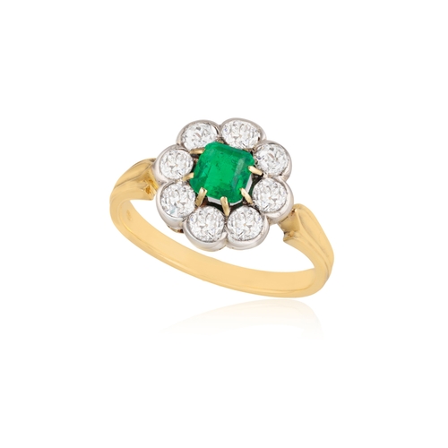 262 - AN EMERALD AND DIAMOND CLUSTER RING  The square-cut emerald set within a eight-claw setting, to a br... 