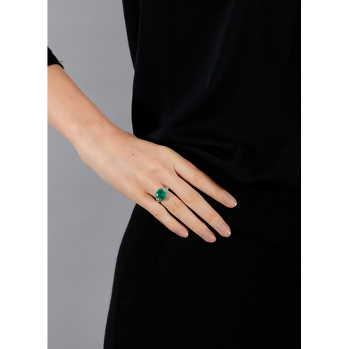 54 - AN EARLY 20TH CENTURY EMERALD AND DIAMOND DRESS RING  The rectangular cut-cornered emerald weighing ... 