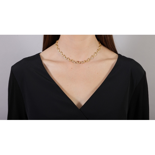 79 - FRED PARIS: A DIAMOND PENDANT NECKLACE, CIRCA 1970  The articulated textured gold chain highlighted ... 