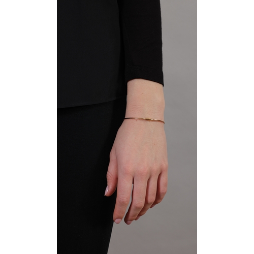 170 - POMELLATO: A GOLD BANGLE  The oval design, the thin polished gold hoop with tonneau clasp, in 18K go... 