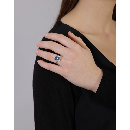 134 - A SAPPHIRE AND DIAMOND CLUSTER RING  Set with a cushion-shaped sapphire weighing 3.62cts, within a f... 