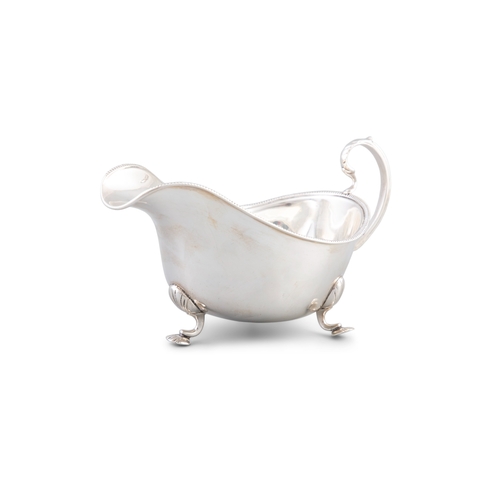 103 - A MODERN SILVER SAUCE BOAT  Birmingham, the plain body with gadrooned rim, c-scroll handle on three ... 