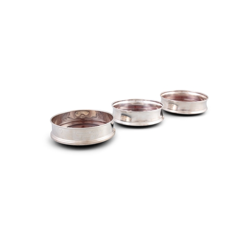 104 - A SET OF THREE MODERN SILVER DECANTER COASTERS,     by Carrs, with out-turned reeded rims, plain bal... 