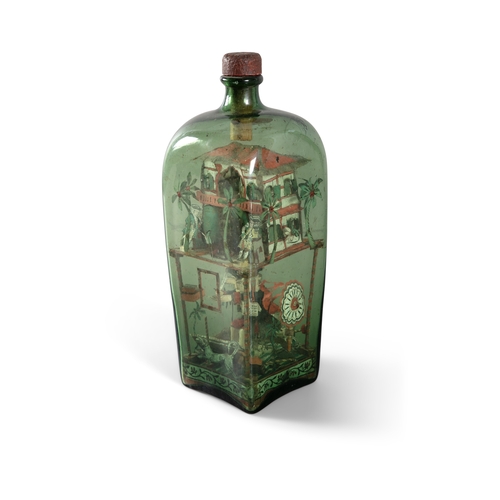 116 - AN INDIAN OLIVE GLASS BOTTLE DIORAMA, 19TH CENTURY,   of square form, with stopper, housing papier m... 