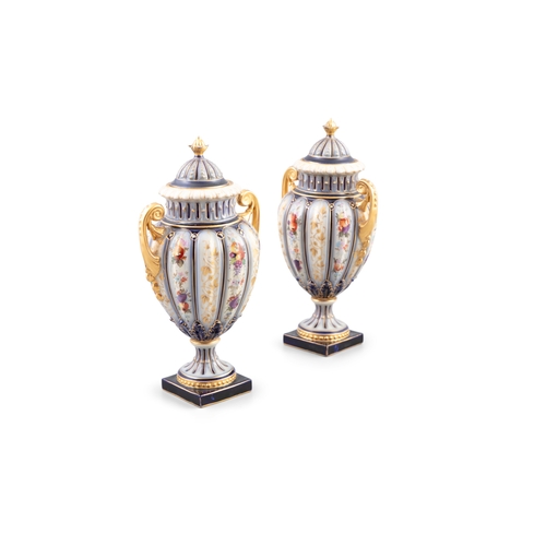 122 - A PAIR OF CONTINENTAL PORCELAIN VASES AND COVERS  each with domed lids and gilt finials, of baluster... 