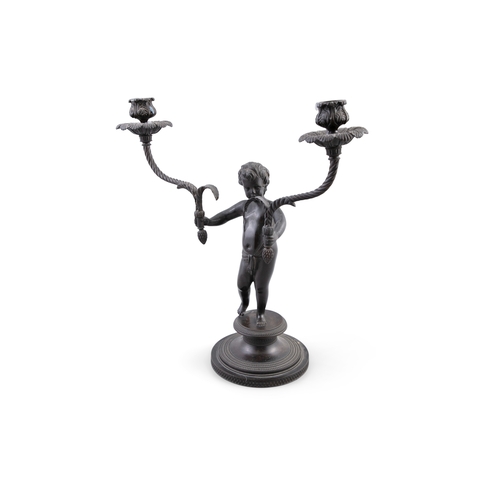 132 - A 19TH CENTURY BRONZE CANDELABRA IN THE FORM OF A YOUNG BOY,   standing, holding a candle sconce in ... 