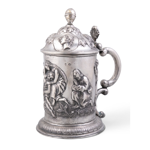 133 - AN EMBOSSED SILVER LIDDED TANKARD,   German / Austrian, 19th century, the domed cover overlaid with ... 