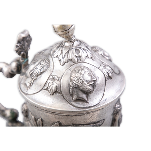 133 - AN EMBOSSED SILVER LIDDED TANKARD,   German / Austrian, 19th century, the domed cover overlaid with ... 