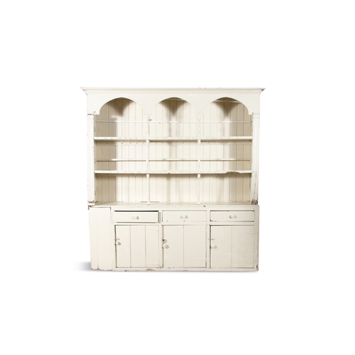 320A - A LARGE WHITE-PAINTED PINE DRESSER,    in two sections, the three-tier back with moulded cornice, th... 