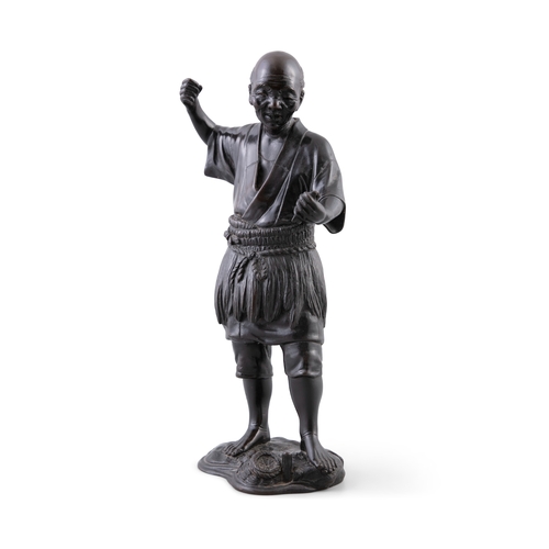 329 - A CHINESE BRONZE FIGURE OF A STANDING FISHERMAN,   holding a fish in his hand, raised on a rocky bas... 