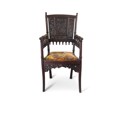 332 - A 19TH CENTURY ANGLO-BURMESE ARMCHAIR  with pierced and elaborately carved back, the arms with monke... 