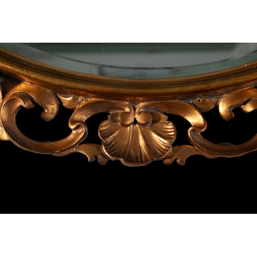 344 - AN OVAL GILTWOOD MIRROR  with scallop shell and pierced scrollwork border, 78 x 59cm