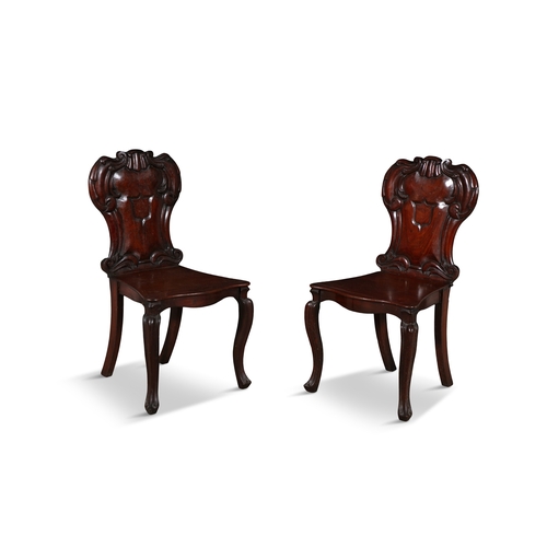 412 - A PAIR OF VICTORIAN MAHOGANY CARVED HALL CHAIRS  each with cartouche shaped panelled back and centre... 