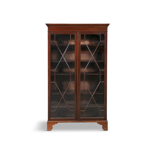 490 - A MAHOGANY TWO-DOOR DISPLAY CABINET  with outset dentil cornice, over twin astragal glazed doors, en... 