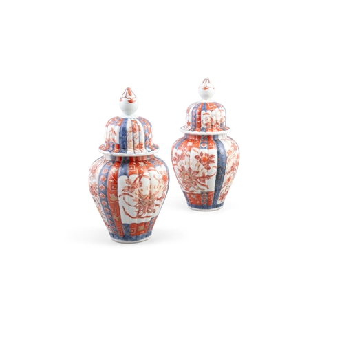 71 - A PAIR OF IMARI PATTERN PORCELAIN VASES AND COVERS  each with domed cover with pointed finial, of ov... 