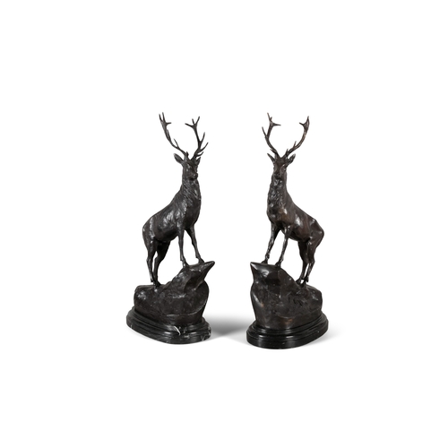 74 - AFTER JULES MOIGNIEZ 20TH CENTURY,  a pair of bronze stags, each modelled standing on a rock mound o... 