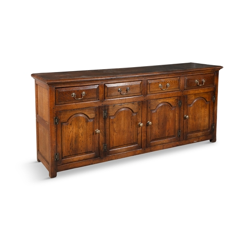 77 - A GEORGIAN STYLE OAK WELSH DRESSER BASE   of rectangular form, the moulded top above four short draw... 