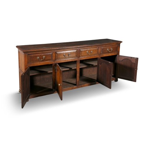 77 - A GEORGIAN STYLE OAK WELSH DRESSER BASE   of rectangular form, the moulded top above four short draw... 