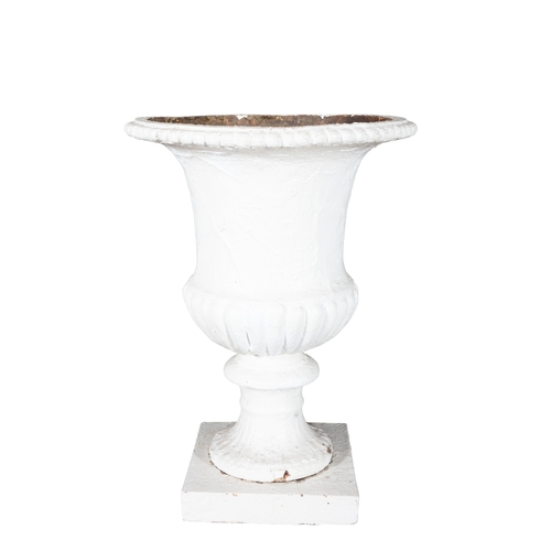 1 - A VICTORIAN WHITE PAINTED CAST IRON GARDEN URN  raised upon a white painted stone plinth of classica... 