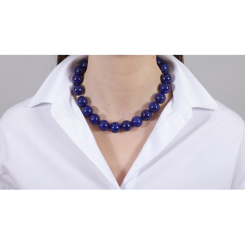 100 - A LAPIS LAZULI BEAD NECKLACE  Composed of a single strand of lapis lazuli beads measuring 18.4mm, to... 