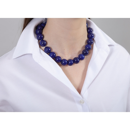 100 - A LAPIS LAZULI BEAD NECKLACE  Composed of a single strand of lapis lazuli beads measuring 18.4mm, to... 