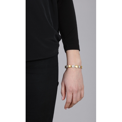 102 - AN 18K GOLD AND DIAMOND BANGLE BRACELET  The square yellow gold links, interspersed with similar whi... 