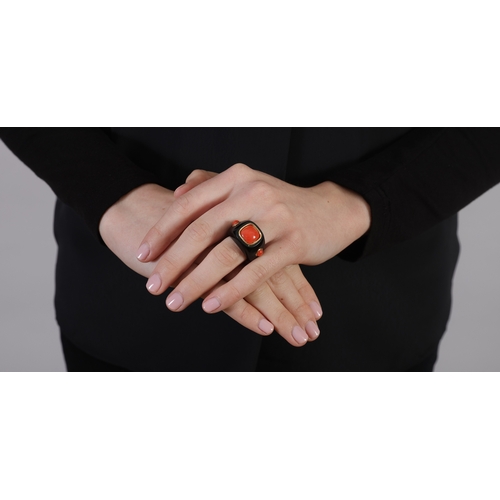 118 - SEAMAN SCHEPPS: A CORAL AND ONYX RING  The broad tapered ring mount composed of polished onyx, set w... 