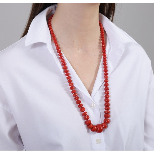 122 - A CORAL BEAD NECKLACE  Composed of a single strand of faceted graduated coral beads, to an oval-shap... 