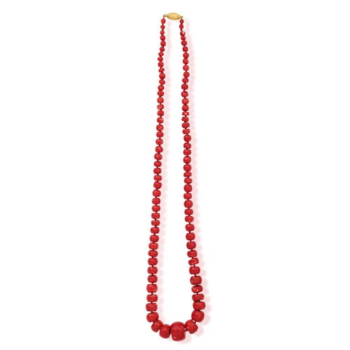 122 - A CORAL BEAD NECKLACE  Composed of a single strand of faceted graduated coral beads, to an oval-shap... 