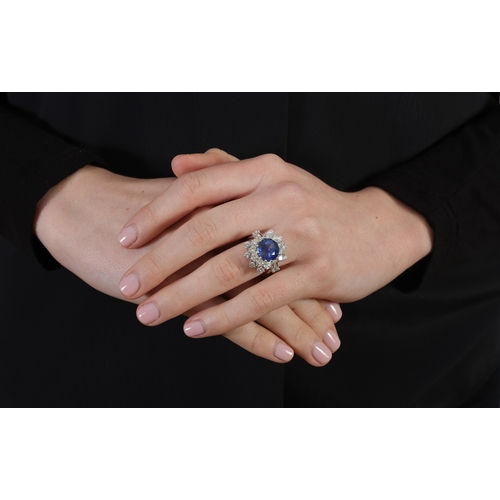 140 - A SAPPHIRE AND DIAMOND RING   Set with a circular-shaped sapphire, within a cluster surround of bril... 