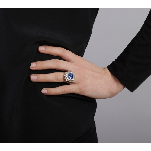 140 - A SAPPHIRE AND DIAMOND RING   Set with a circular-shaped sapphire, within a cluster surround of bril... 