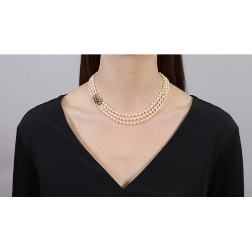 141 - A CULTURED PEARL, SAPPHIRE AND DIAMOND NECKLACE  Composed of three strands of round-shaped cultured ... 