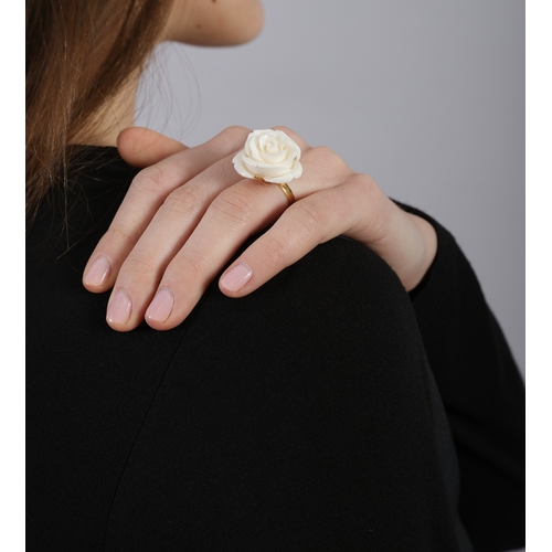 203 - A  CORAL RING  The carved coral rose flowerhead, mounted in 18K gold, French import mark, flowerhead... 