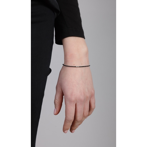 221 - A DIAMOND LINE BRACELET  Claw-set with brilliant-cut black diamonds in square-shaped mounts, mounted... 