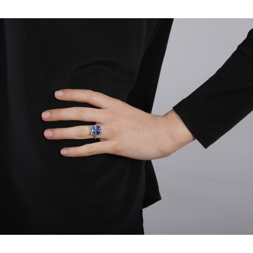 224 - A SYNTHETIC SAPPHIRE AND DIAMOND RING  Set with a cushion-shaped synthetic sapphire weighing approxi... 