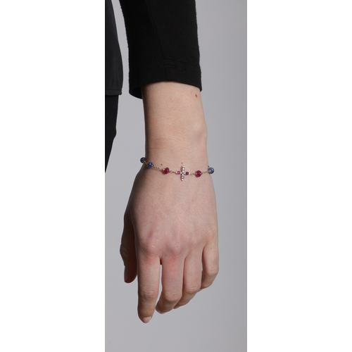 245 - A RUBY, SAPPHIRE AND DIAMOND BRACELET  Centring a cross motif set with circular-shaped rubies, to a ... 